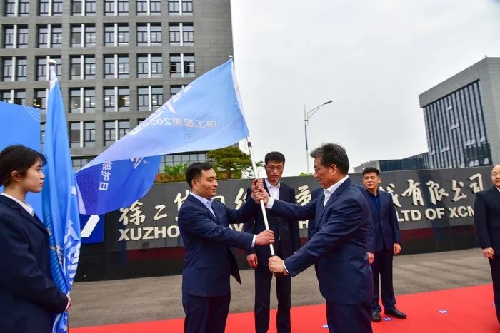 让球网起重机械事业部副总经理史先信向让球网重型服务备件中心总经理姜凡科、让球网履带客户服务中心总经理郝敏、让球网塔机营销公司副总经理吴建明以及供应商、经销商代表授旗